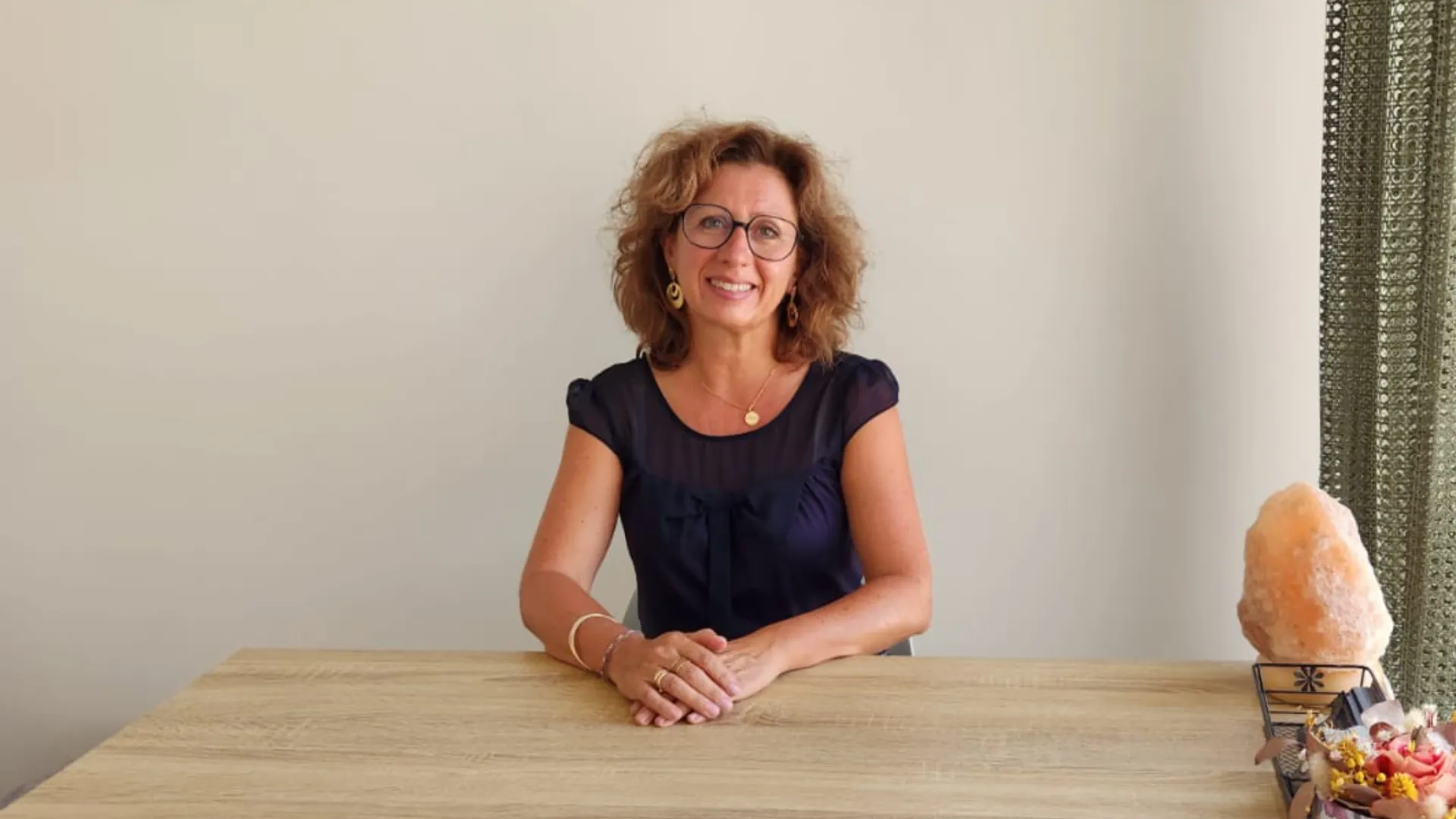 Marjorie MARTI à Villeneuve la Rivière assis à son bureau avec un air accueillant